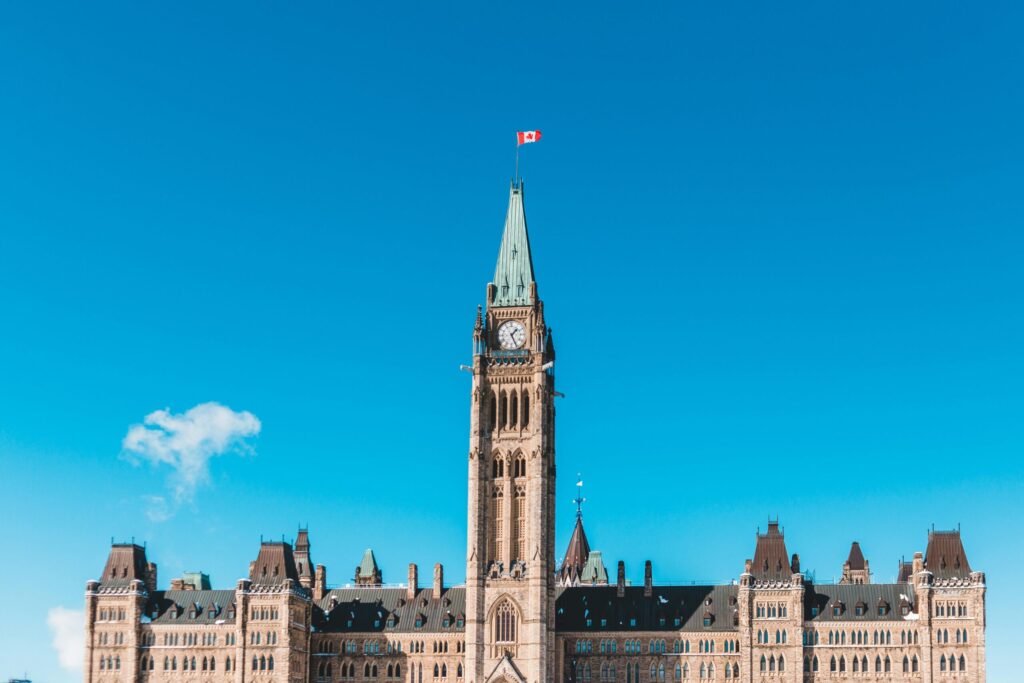 The Peace Tower of Canada's Parliament in bright daylight against a blue sky.